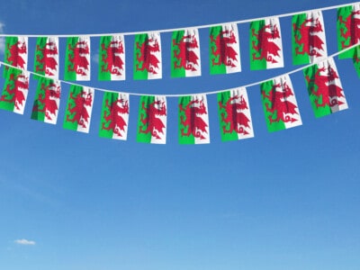 Wales Flag Festive Bunting Hanging Against A Blue Sky. 3d Render